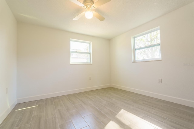 spare room featuring ceiling fan, a healthy amount of sunlight, and light wood-type flooring