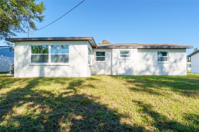 rear view of house featuring a lawn