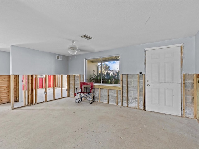 misc room with ceiling fan and a textured ceiling