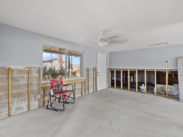 misc room with ceiling fan and concrete flooring