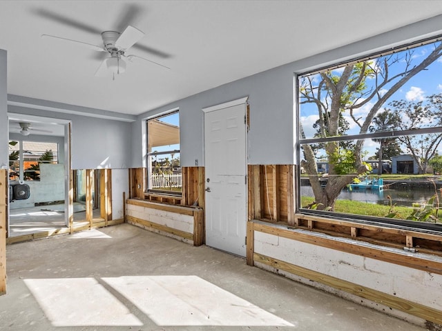 interior space featuring a water view, a wealth of natural light, and ceiling fan