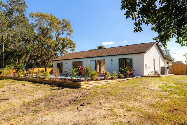 rear view of house featuring a yard and cooling unit