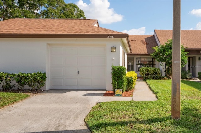 view of front facade featuring a front yard and a garage