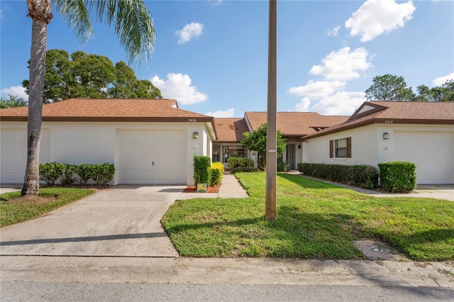 single story home with a garage and a front lawn