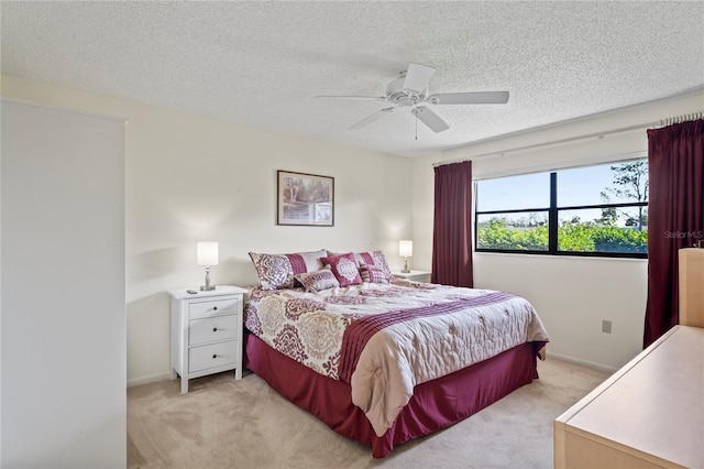 carpeted bedroom featuring a textured ceiling and ceiling fan