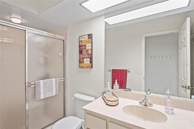 bathroom featuring vanity, toilet, and a shower with shower door