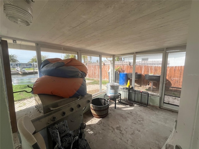 sunroom featuring a water view and wood ceiling