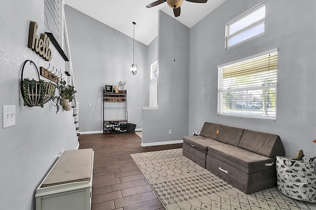 living room featuring ceiling fan, high vaulted ceiling, and wood-type flooring