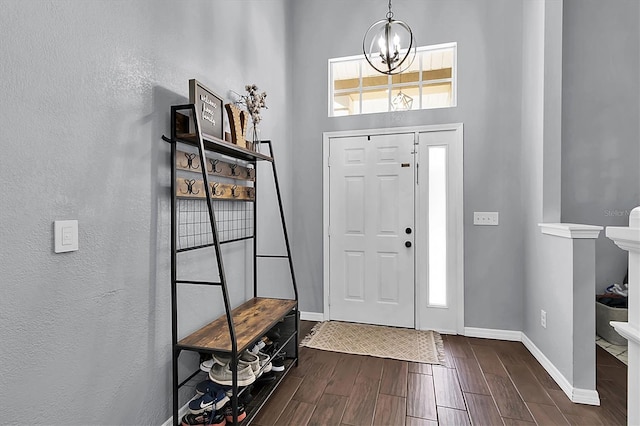 foyer entrance featuring dark wood-type flooring and a chandelier