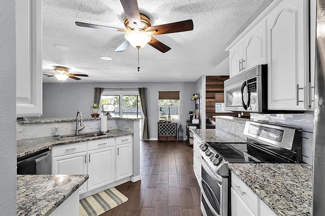 kitchen featuring light stone countertops, stainless steel appliances, and white cabinetry