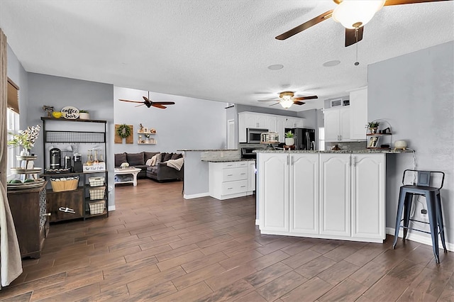 kitchen featuring white cabinets, dark hardwood / wood-style floors, and black fridge