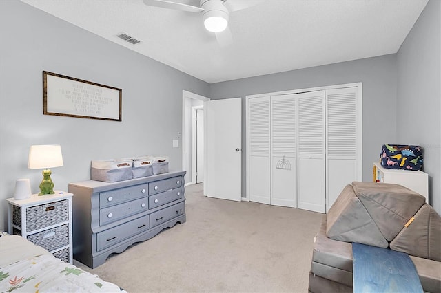 carpeted bedroom with ceiling fan and a closet