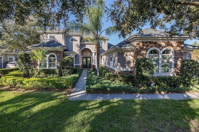 mediterranean / spanish home featuring a front lawn