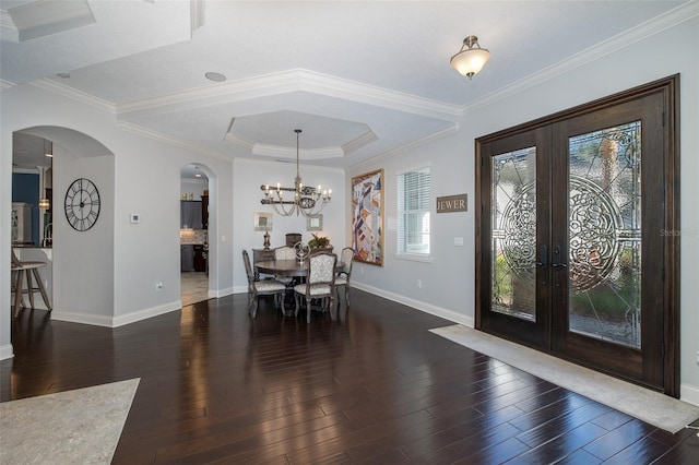 dining room with a notable chandelier, dark hardwood / wood-style flooring, crown molding, and french doors