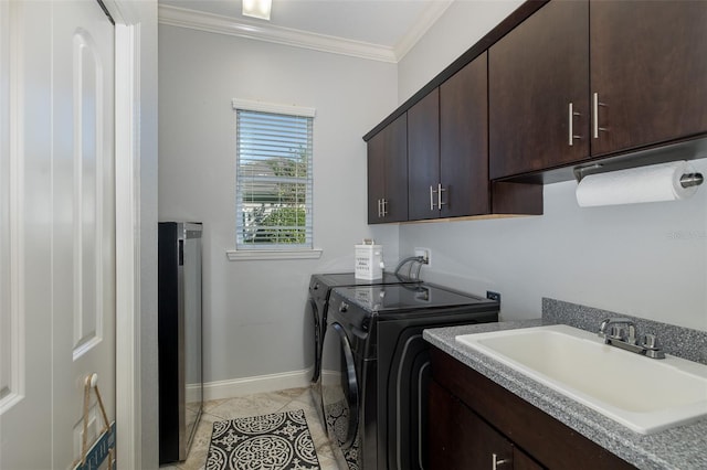 laundry area featuring cabinets, ornamental molding, washer and clothes dryer, sink, and light tile patterned flooring