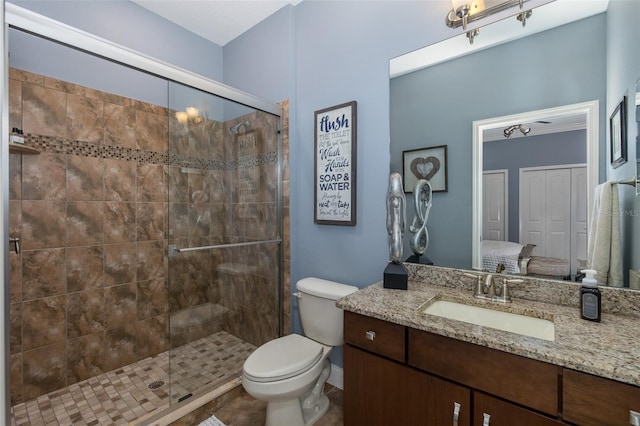 bathroom featuring vanity, toilet, and a shower with door