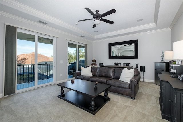 carpeted living room featuring a mountain view, a tray ceiling, ceiling fan, and ornamental molding