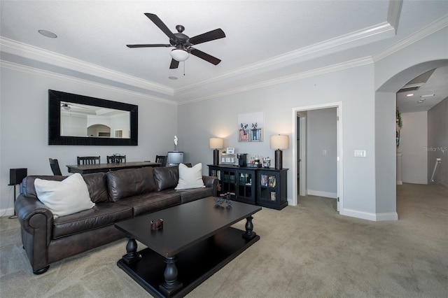 carpeted living room featuring a tray ceiling, ceiling fan, and crown molding