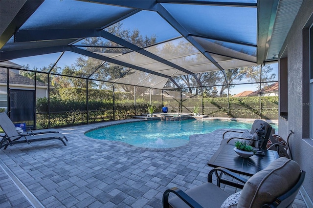 view of swimming pool with glass enclosure, an in ground hot tub, and a patio