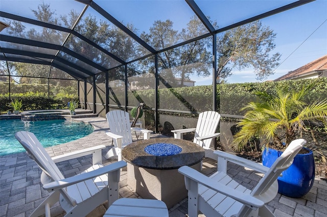 view of patio with glass enclosure, a swimming pool with hot tub, and an outdoor fire pit