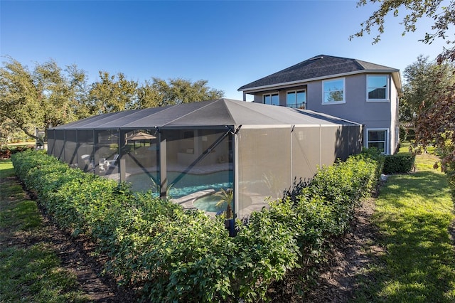 view of pool with a lanai and a lawn