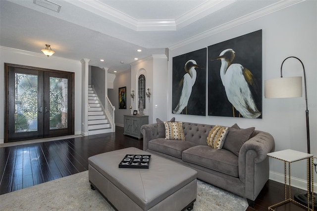 living room featuring french doors, dark hardwood / wood-style floors, a raised ceiling, and ornamental molding