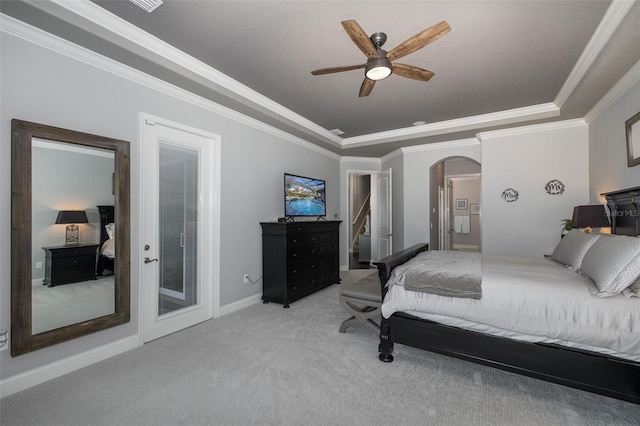 carpeted bedroom featuring a raised ceiling, ceiling fan, and crown molding