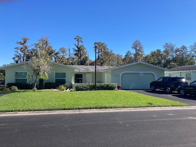 ranch-style house with a garage and a front lawn