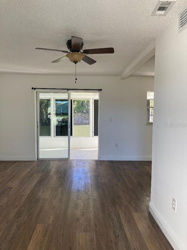 empty room with beam ceiling, ceiling fan, dark hardwood / wood-style flooring, and a textured ceiling