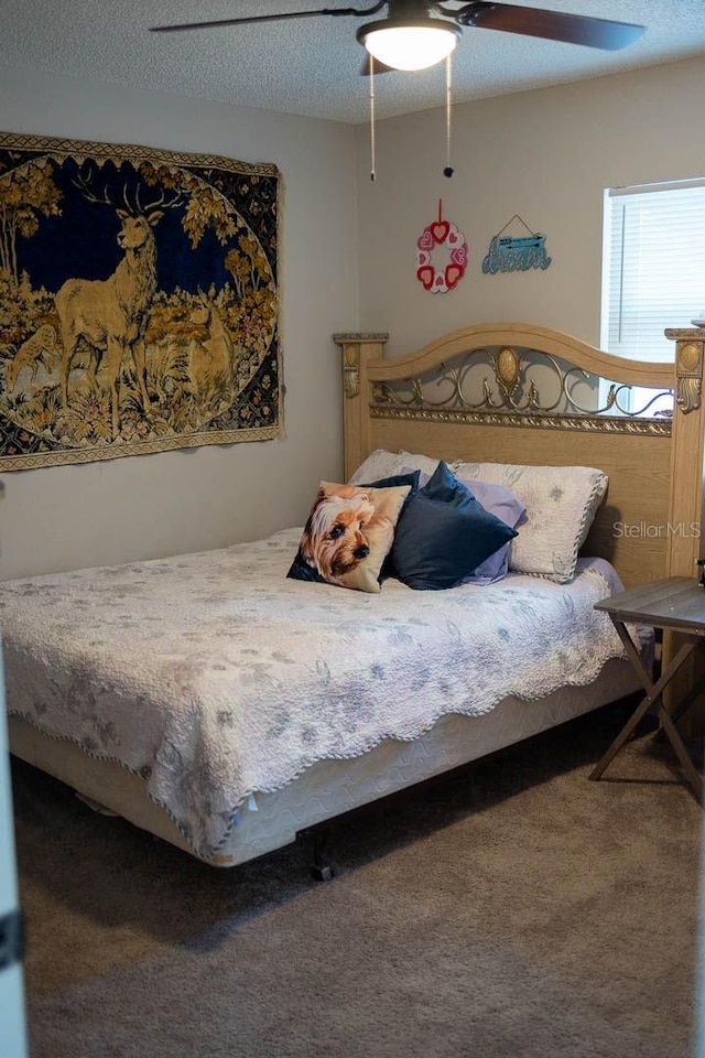 bedroom with carpet flooring, ceiling fan, and a textured ceiling