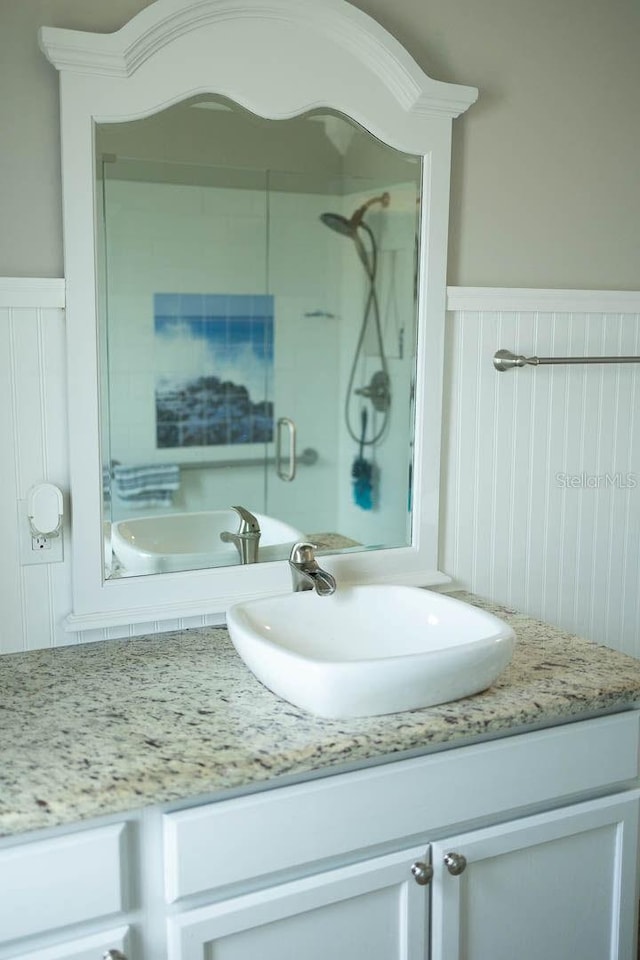 bathroom featuring a tile shower and vanity