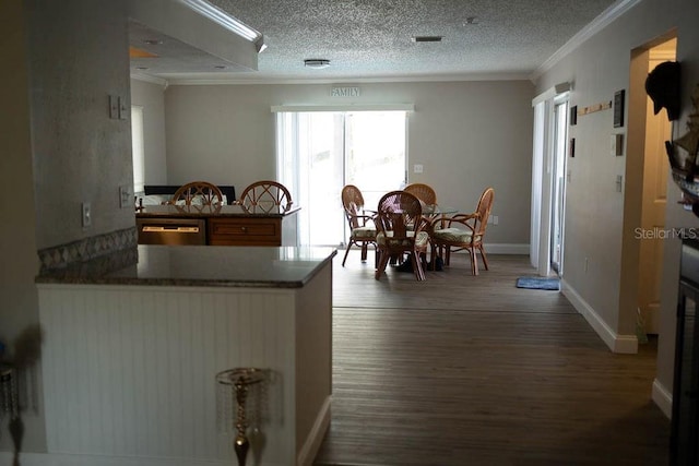 kitchen featuring hardwood / wood-style floors, stainless steel dishwasher, ornamental molding, a textured ceiling, and kitchen peninsula