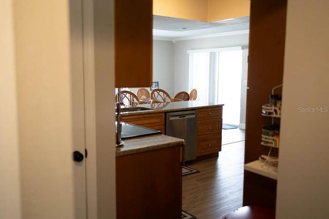 kitchen featuring hardwood / wood-style floors, sink, stainless steel dishwasher, ornamental molding, and kitchen peninsula