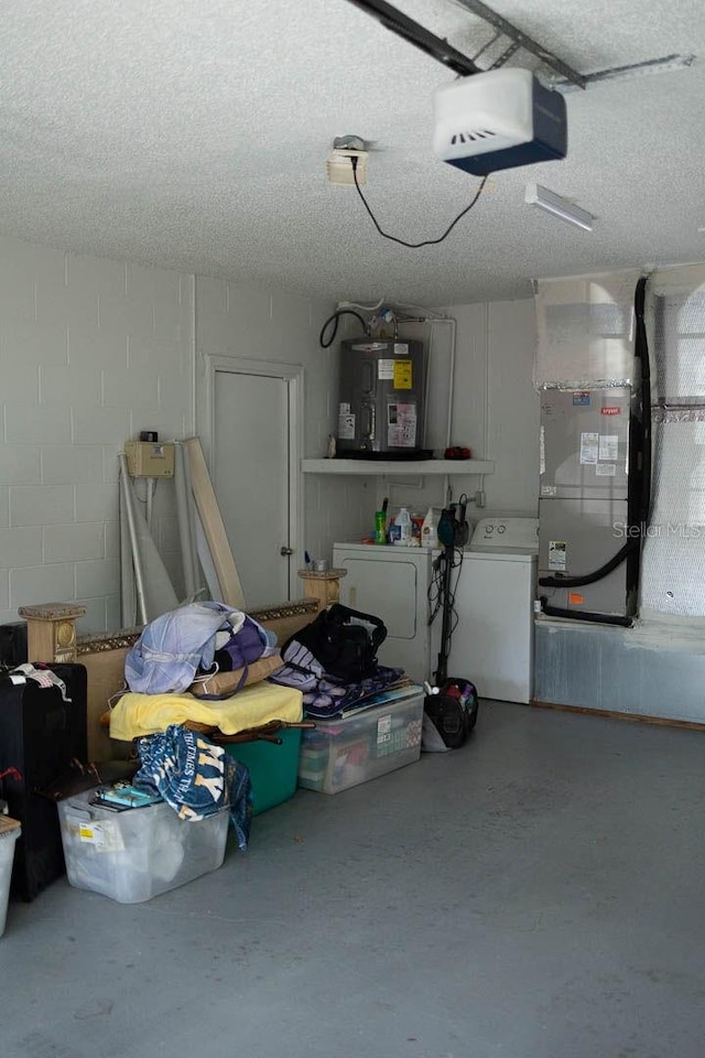 garage featuring washing machine and clothes dryer, heating unit, water heater, and a garage door opener