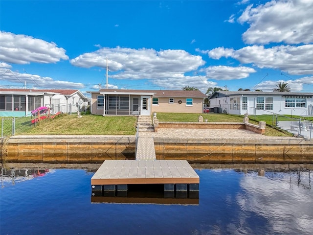 dock area featuring a water view and a lawn