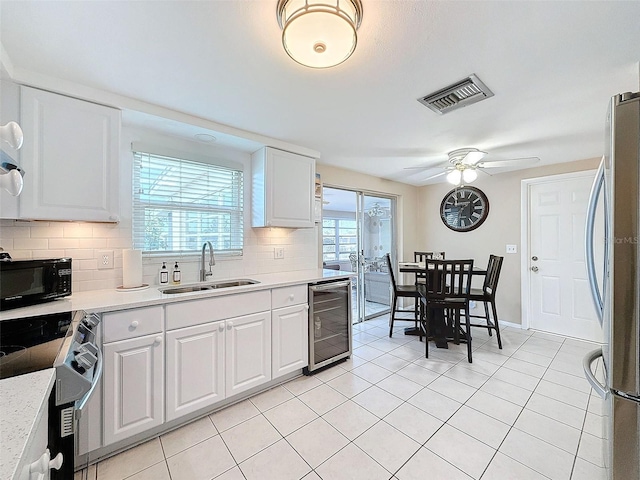 kitchen featuring wine cooler, ceiling fan, sink, white cabinetry, and appliances with stainless steel finishes