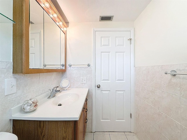 bathroom featuring vanity, tile patterned flooring, and tile walls