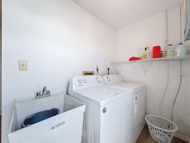 laundry area featuring separate washer and dryer, hardwood / wood-style flooring, and sink