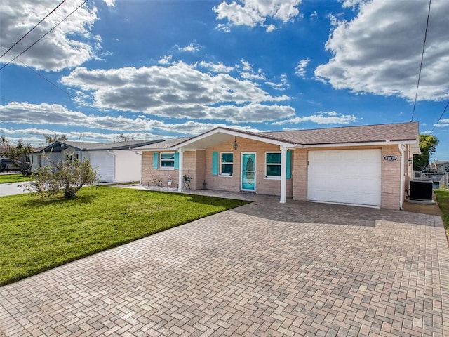 ranch-style home featuring a front lawn, central air condition unit, a porch, and a garage