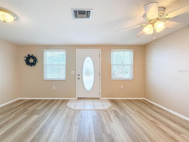 foyer entrance featuring ceiling fan, a wealth of natural light, and light hardwood / wood-style floors