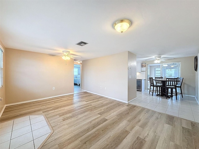 unfurnished room featuring wine cooler and light hardwood / wood-style flooring