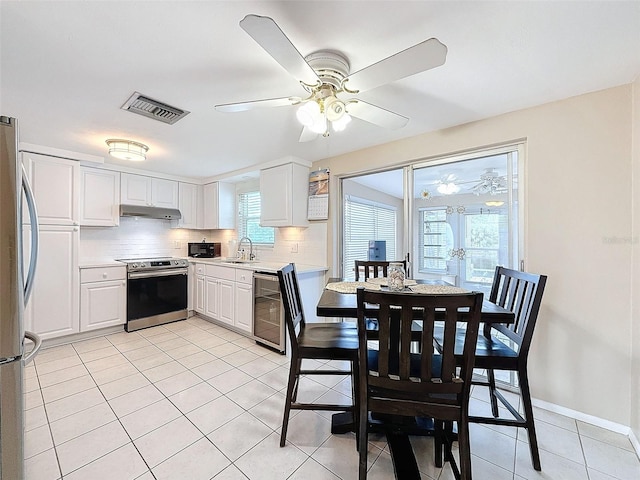 kitchen with tasteful backsplash, white cabinets, sink, and stainless steel appliances