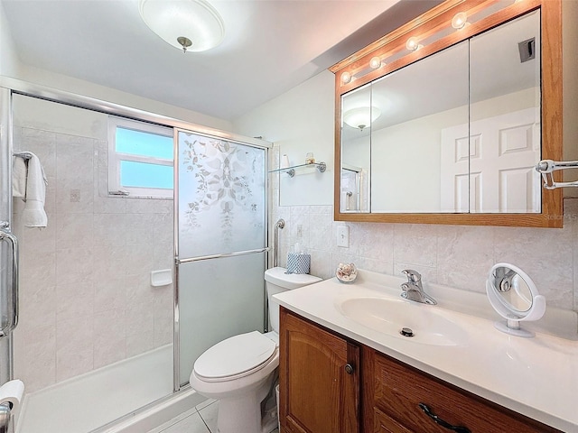 bathroom featuring tile patterned flooring, vanity, tile walls, toilet, and a shower with shower door