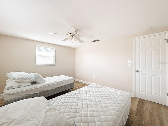 bedroom with ceiling fan and wood-type flooring