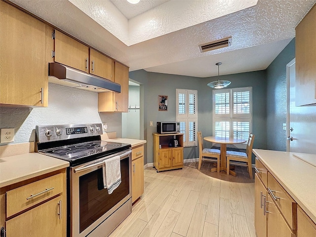 kitchen featuring light wood-type flooring, appliances with stainless steel finishes, a textured ceiling, and decorative light fixtures