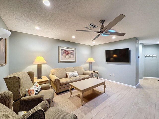 living room featuring light hardwood / wood-style floors and a textured ceiling