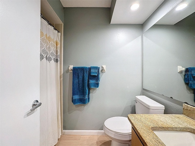 bathroom with hardwood / wood-style floors, vanity, and toilet