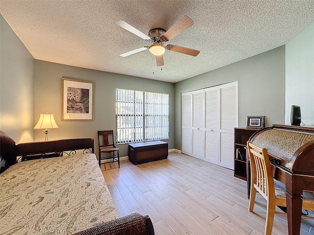 bedroom featuring a textured ceiling, ceiling fan, light hardwood / wood-style flooring, and a closet