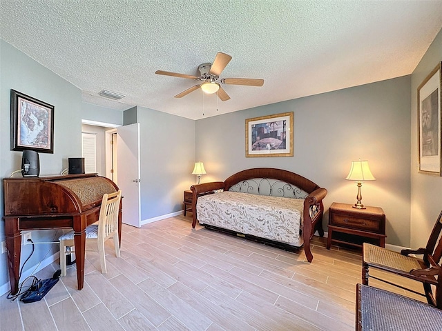 bedroom featuring a textured ceiling, light wood-type flooring, and ceiling fan