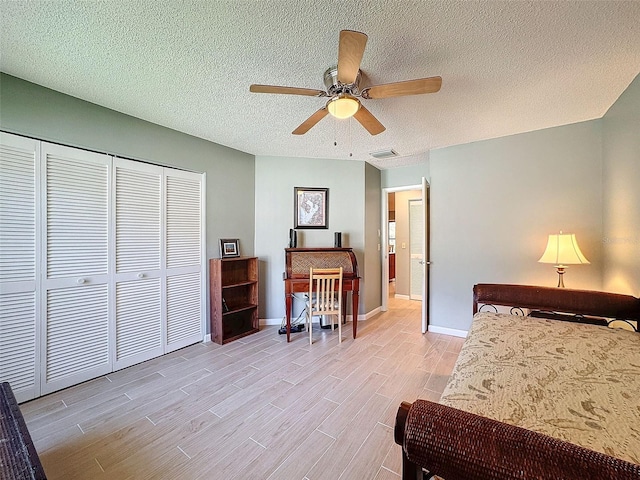 bedroom with ceiling fan, light wood-type flooring, a textured ceiling, and a closet